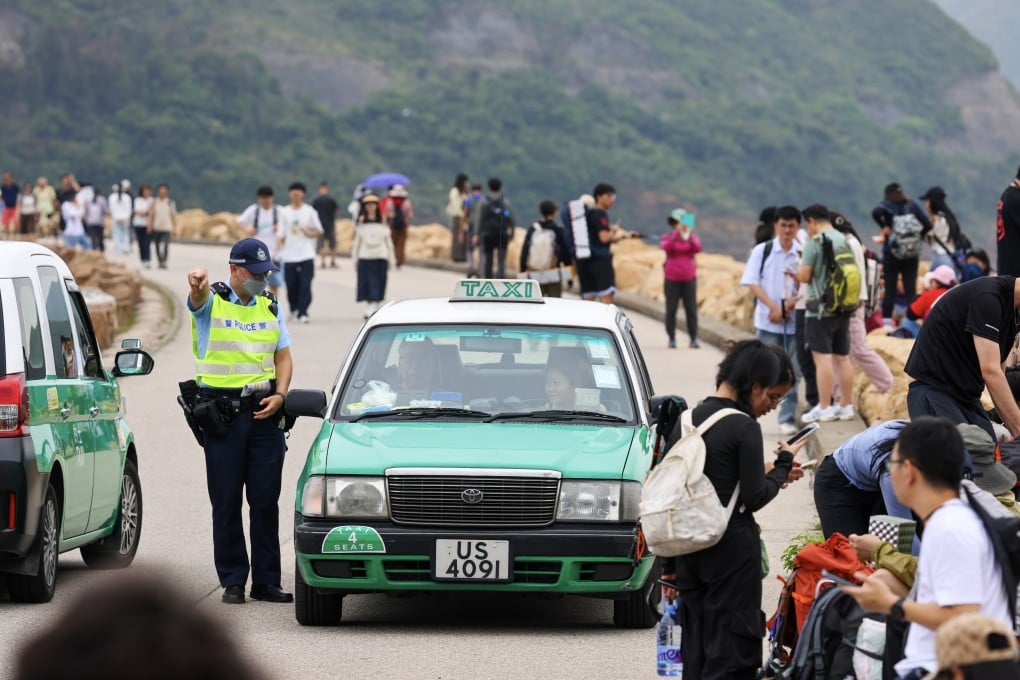 A policeman directs a taxi as hikers visit High Land Reservoir in Sai Kung on May 1. Photo: Dickson Lee