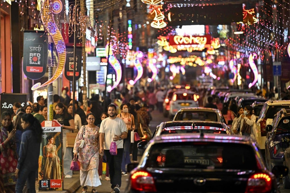 Shoppers walk along a street illuminated with decorative lights ahead of New Year celebrations in Bengaluru, India, last month. Photo: AFP