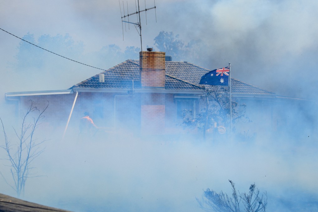 Smoke shrouds a home in Longwood, Australia’s Victoria state, on Friday as firefighters attempt to douse the flames. Photo: AAP/Reuters