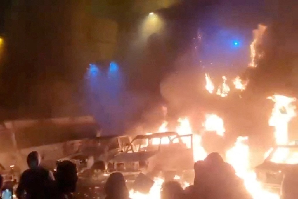 Protesters gather as vehicles burn, amid evolving anti-government unrest in Tehran, Iran, in a social media image released on Friday. Photo: Social media via Reuters