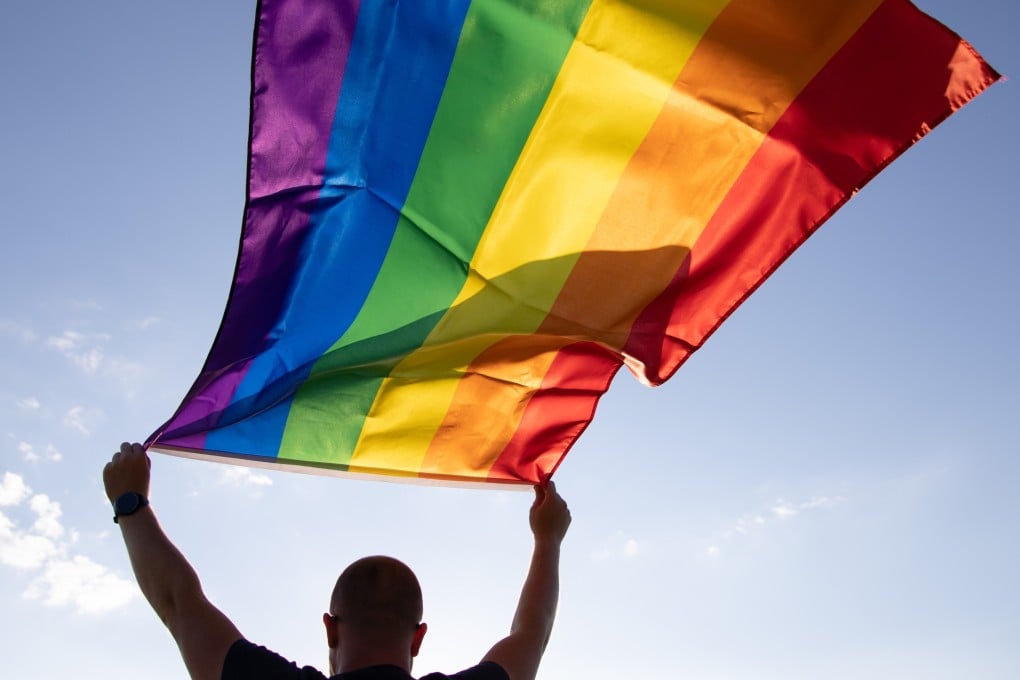 A man holds a rainbow flag, commonly used to signal LGBT pride. Photo: Shutterstock