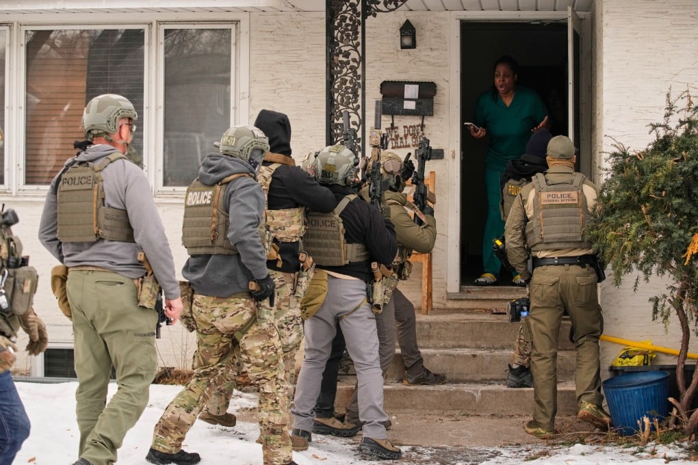 A woman reacts after a federal immigration officer used a battering ram to break down a door before making an arrest in Minneapolis on Sunday. Photo: AP