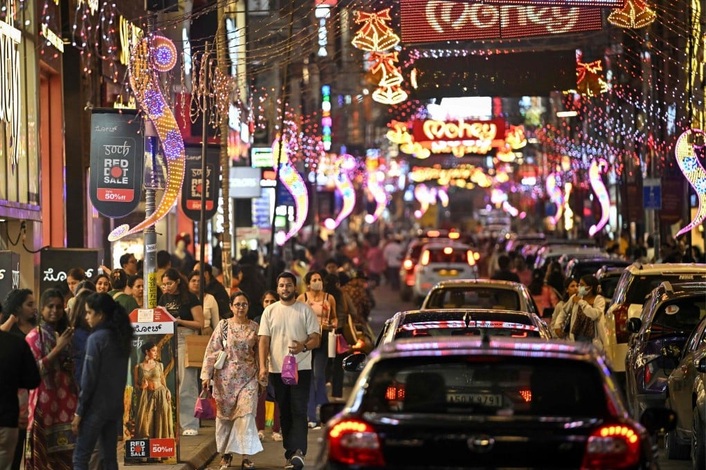 Shoppers walk along a street illuminated with decorative lights ahead of New Year celebrations in Bengaluru, India, last month. Photo: AFP