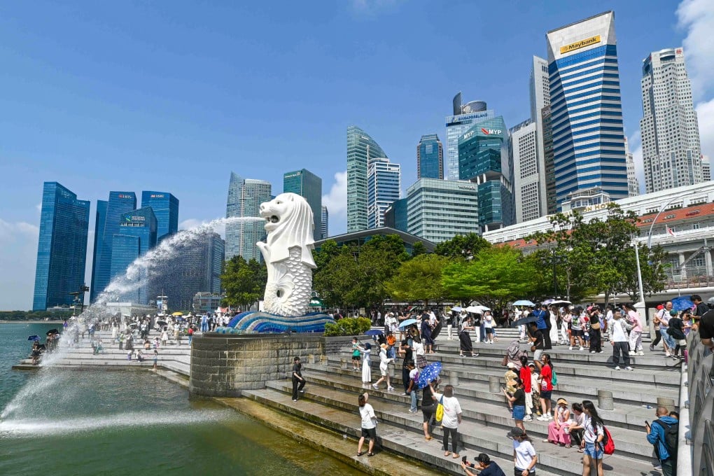 People take pictures next to the Merlion statue at the Marina Bay waterfront in Singapore. Photo: AFP