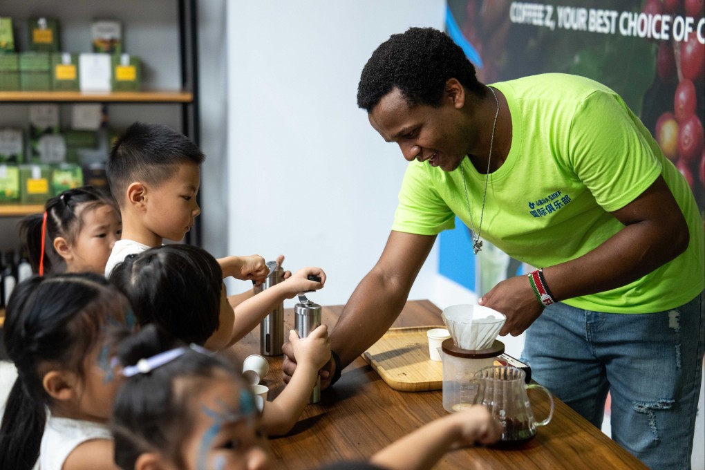 A volunteer grinds coffee beans with children at a China-Africa economic and trade cooperation promotion park, in China’s Hunan province last August. Photo: Xinhua