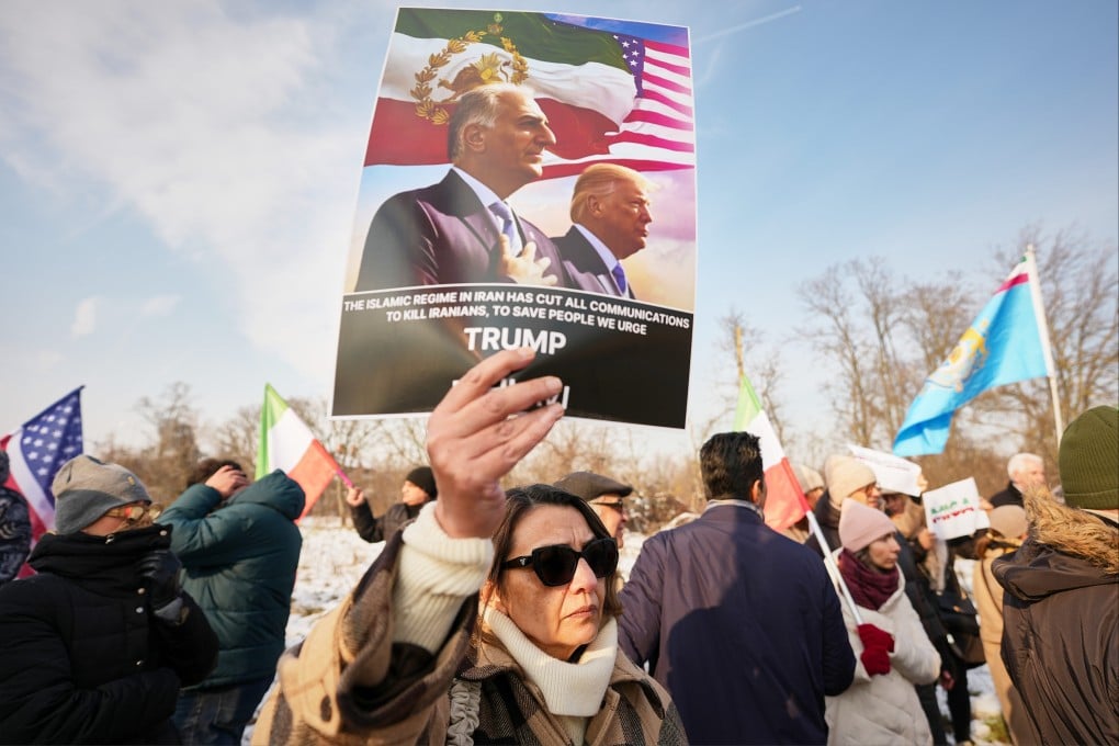 A member of the Iranian community holds a poster depicitng Iran’s exiled crown prince Reza Pahlavi and US President Donald Trump outside the US embassy in Bucharest, Romania, on Wednesday. Photo: AP