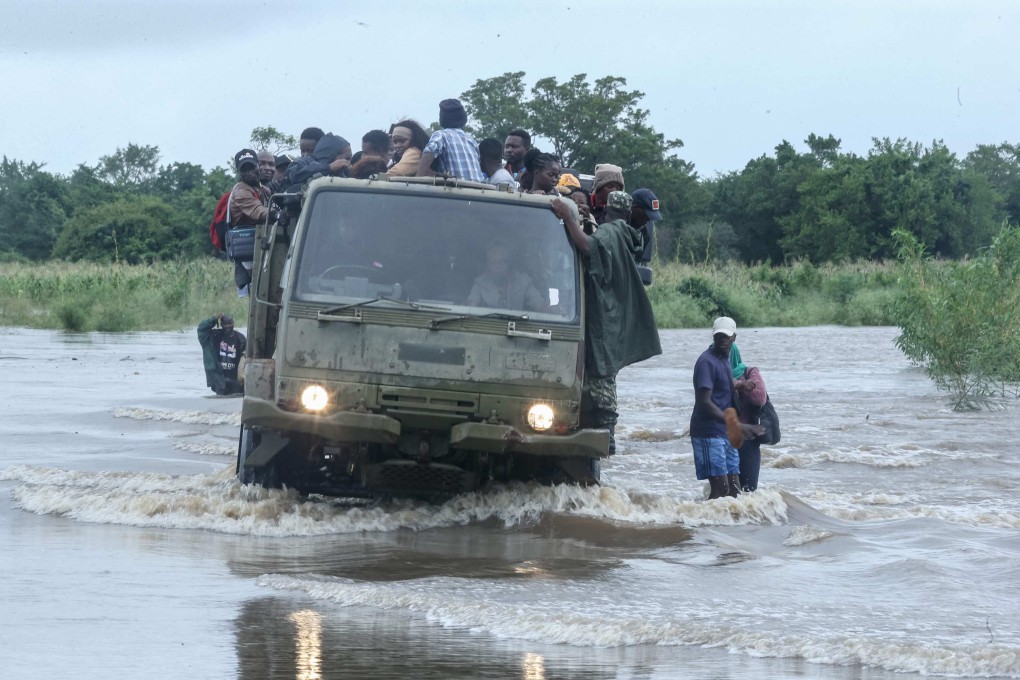 Residents sit on a Mozambique military truck transporting them across floodwater that blocked a road in the Boane district on Friday. Photo: AFP