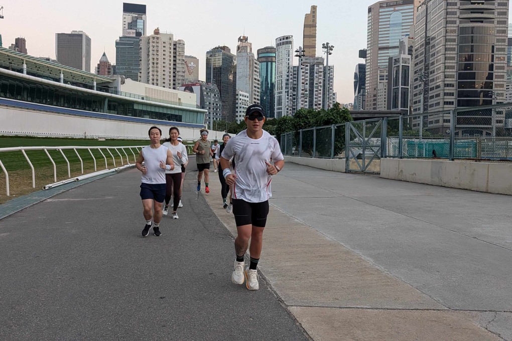 Trainer Michael Sik leads a small group of running enthusiasts around the outer track at Happy Valley Racecourse. Photo: Chieu Luu