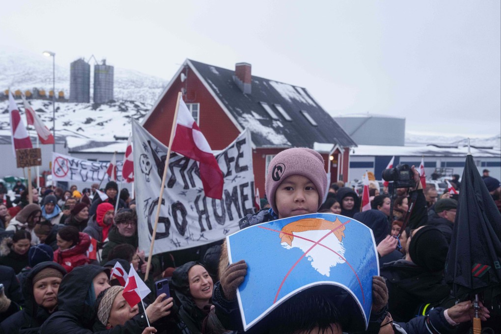 A boy holds a crossed out map of Greenland topped by a hairpiece symbolizing US President Donald Trump, during a protest against Trump’s policy toward Greenland in front of the US consulate in Nuuk, Greenland, on Saturday. Photo: AP