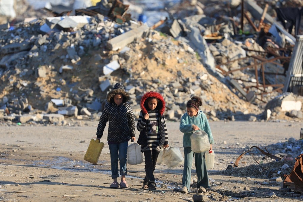 Palestinian girls walk past the rubble of residential buildings destroyed during the war in Gaza City on Friday. Photo: Reuters