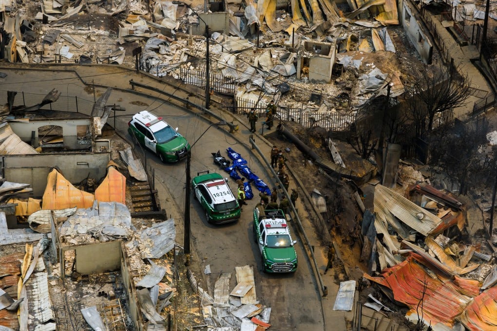 Police recover bodies after wildfires swept through homes near Lirquen, Chile. Photo: AP