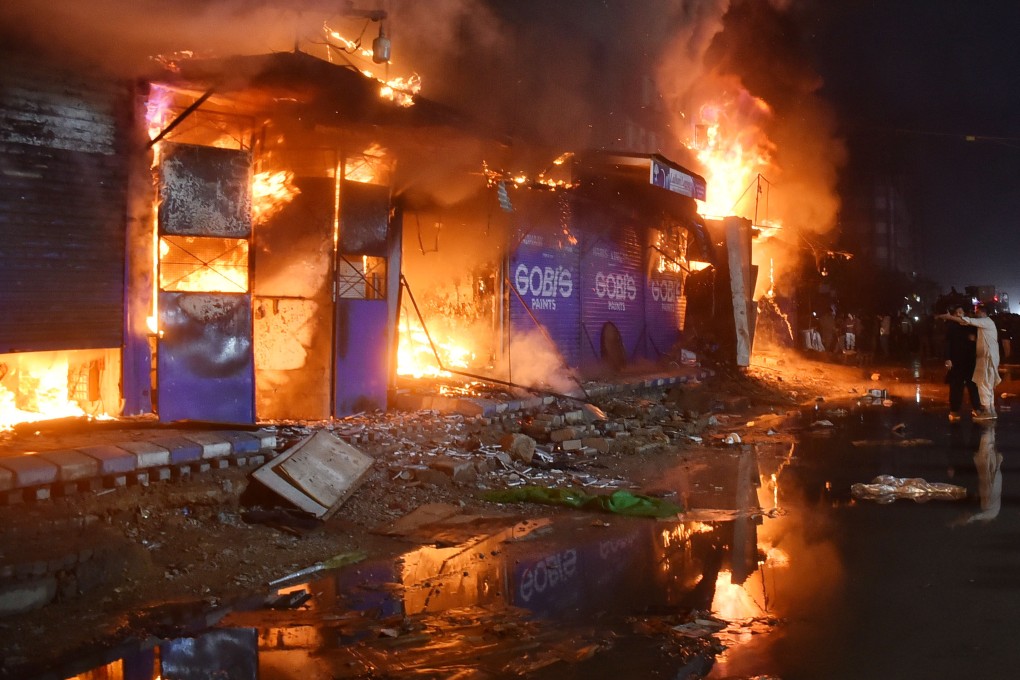 Locals gather to observe a massive fire sweeping through a shopping mall in Karachi on Sunday. Photo: Xinhua