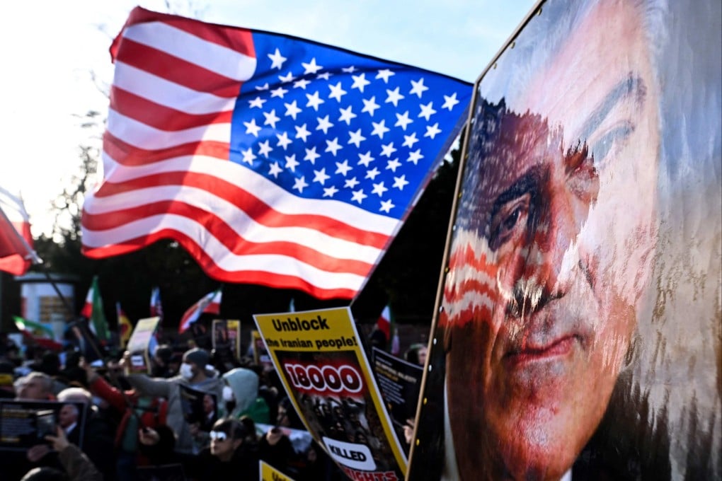 People hold up US flags and portraits of Reza Pahlavi in front of the US consulate in Frankfurt, Germany on Friday. Photo: AFP