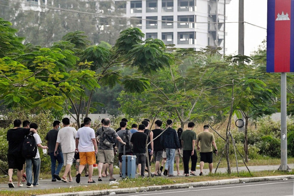 Workers walk out of a suspected scam compound in Sihanoukville on January 15, after Chen Zhi, the alleged kingpin of one of Asia’s largest cyber scam organisations, was arrested in Cambodia and sent to China. Photo: AFP