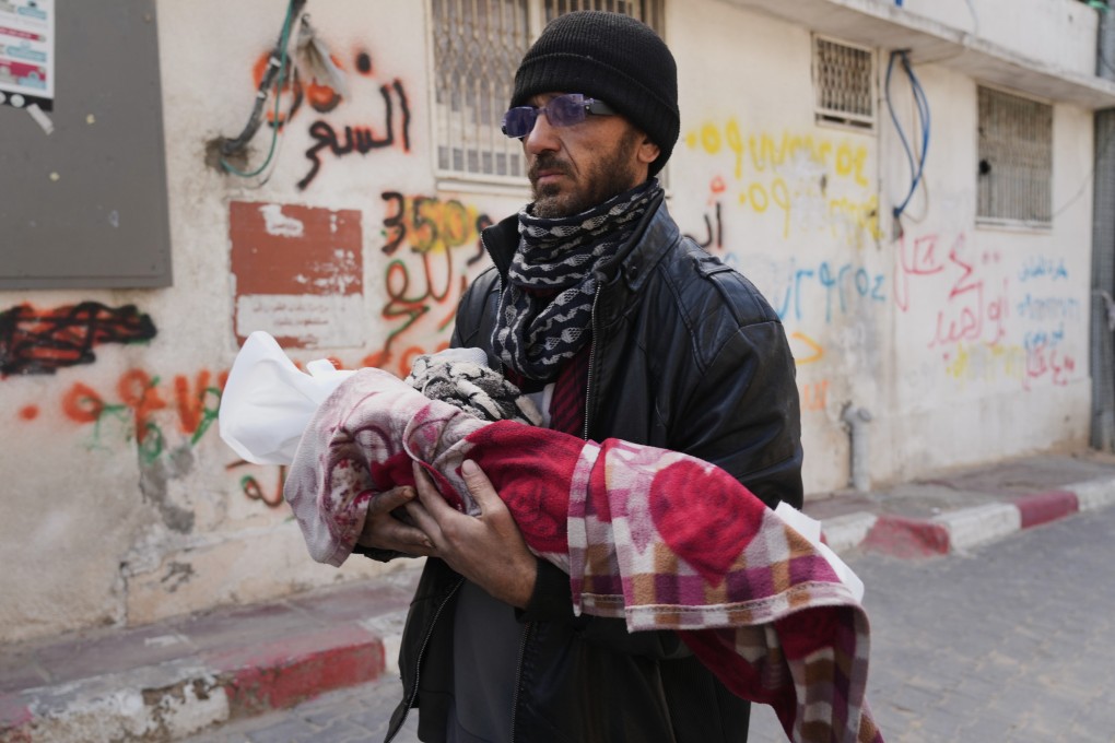 Khalid Abu Jarad holds the body of his 3-month-old niece, Shaza Abu Jarad, who health officials say died on Tuesday from hypothermia. Photo: AP