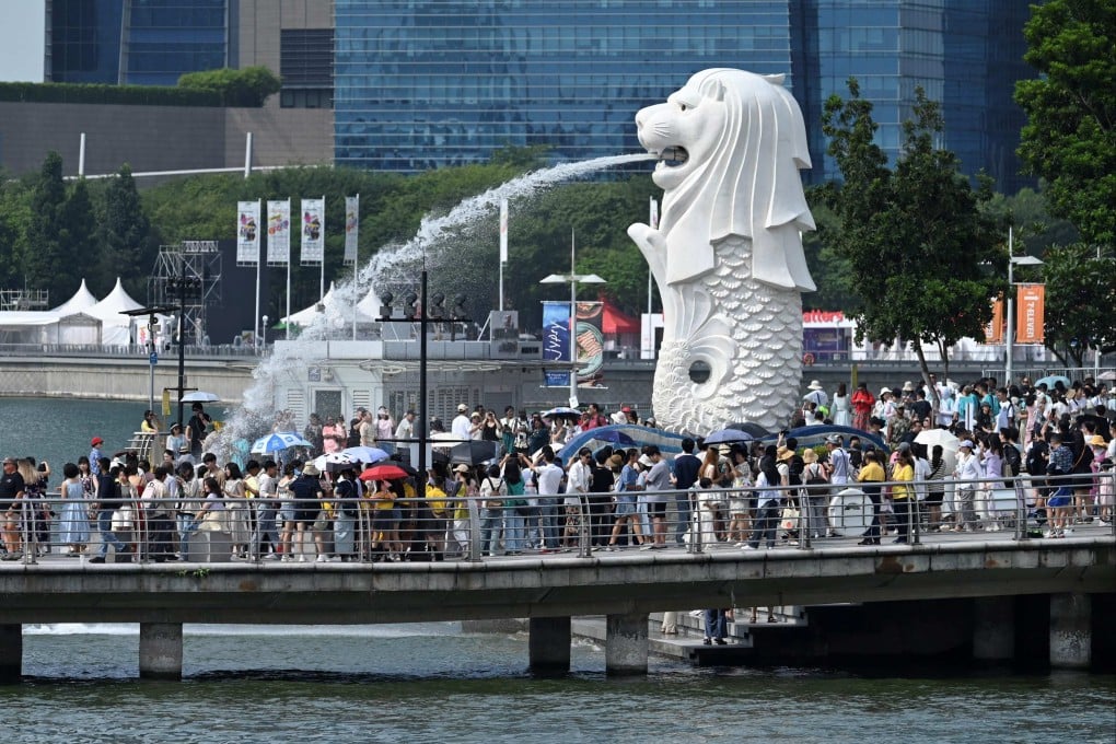 People gather next to the Merlion statue at the Marina Bay Waterfront Promenade in Singapore. Photo: AFP