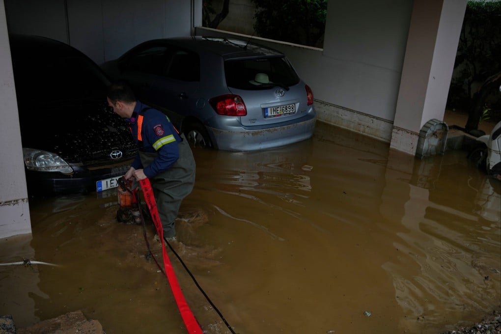 A firefighter pumps water from a parking garage after flooding caused by heavy rain in the Glyfada district of Athens on Thursday. Photo: AP