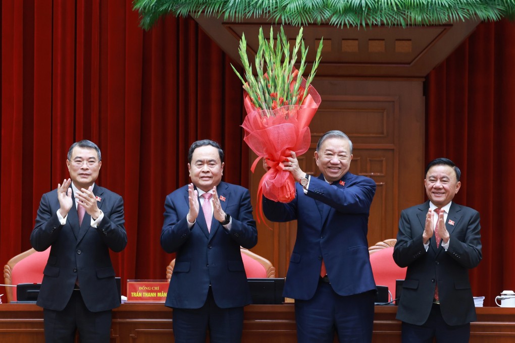 Vietnam’s Communist Party chief To Lam (second right) holds up a bouquet after being re-elected to the position in Hanoi on Friday. Photo: VNA via AP