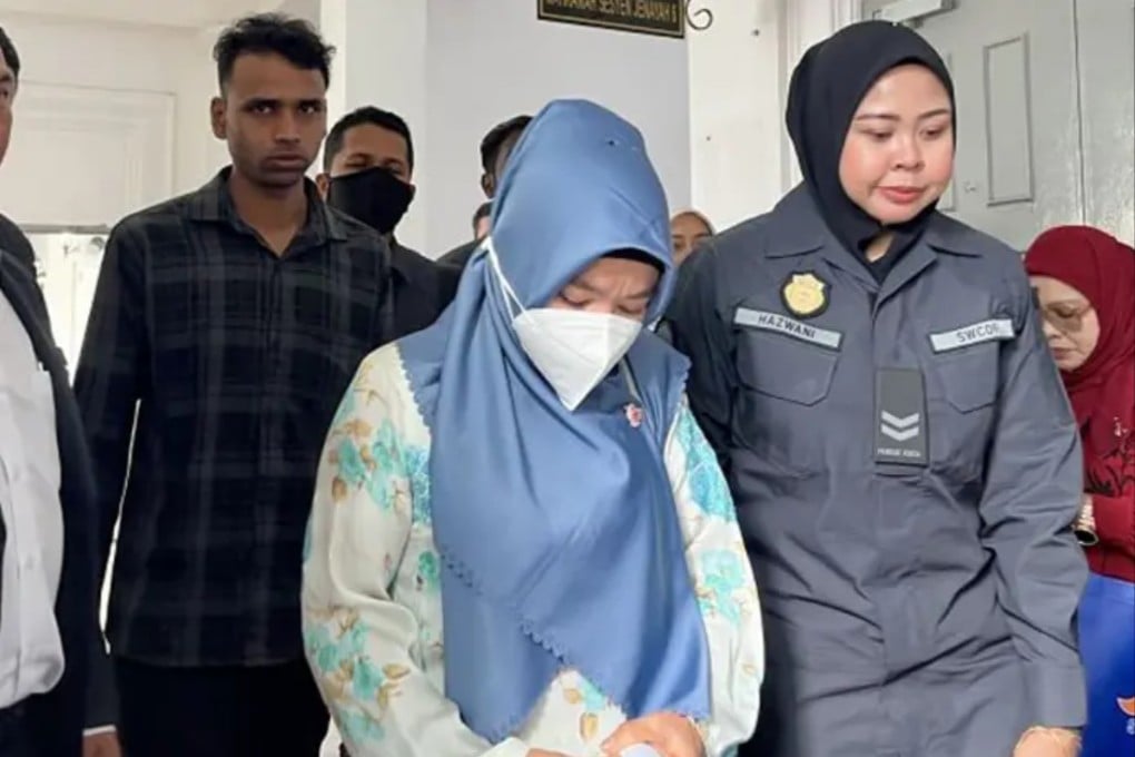 Sultan Md (left) and Anita Lukman (centre) being led into the Sessions Court in Johor Bahru where they were charged with littering in public. Photo: The Star