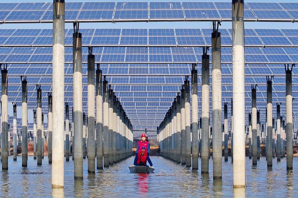 Workers check solar panels on a lake in Tianchang, eastern China’s Anhui province, on January 12. China’s industrial scale effectively functions as a “green” subsidy for the planet. Photo: AFP