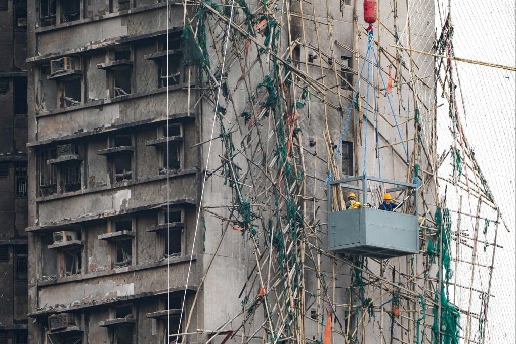 Workers remove damaged bamboo scaffolding at Wang Fuk Court in Tai Po. Photo: Sam Tsang