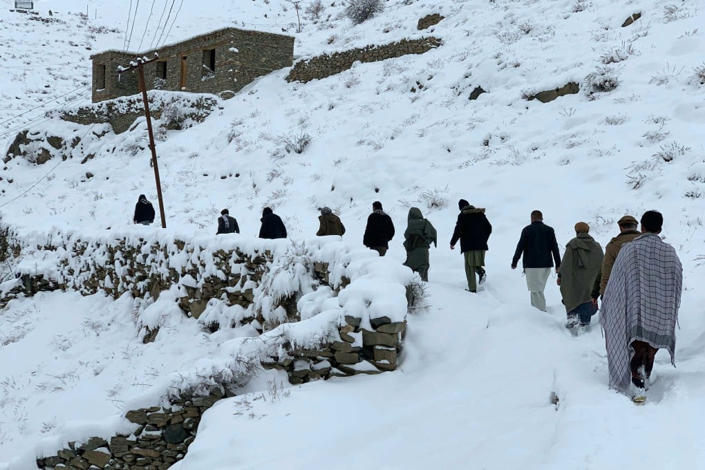 Afghan men walk along a snow-covered path in Panjshir province on Friday. Photo: AFP