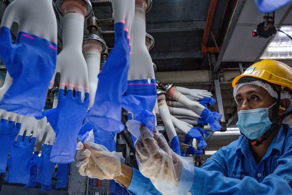 A worker inspects disposable gloves at Top Glove’s factory in Shah Alam, on the outskirts of Kuala Lumpur. Photo: AFP