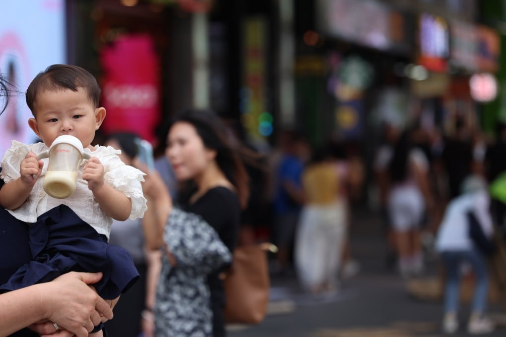 A baby drinks milk in Hong Kong’s Tsim Sha Tsui district on September 19, 2025. Economic pressures such as the cost of living and work-life imbalance make parenting challenging. Photo: Jelly Tse