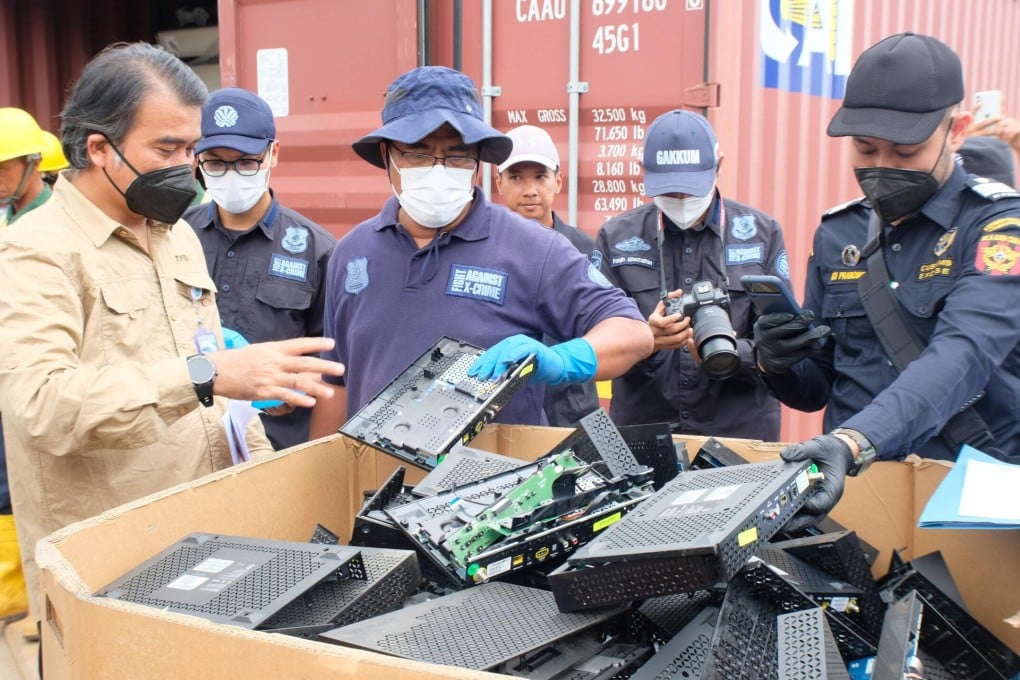 Indonesian customs and environmental enforcement officers inspect discarded electronic equipment seized from containers at Batu Ampar port in Batam in October. Photo: Batam Customs
