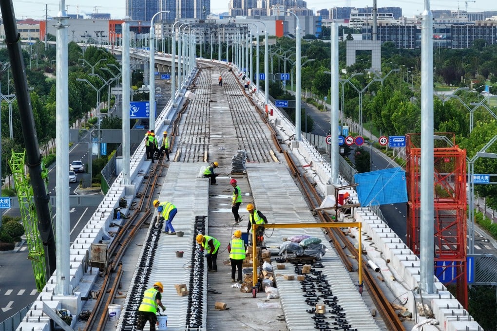 Workers lay track at a construction site in China’s Jiangsu province. Photo: Getty Images