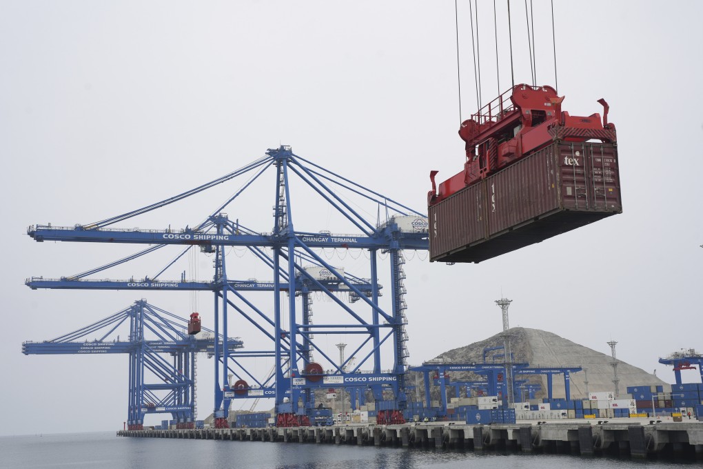 A container is lifted by a crane backdropped by the construction of the Chinese-funded mega port, in Chancay, Peru, on October 29, 2024. Photo: AP