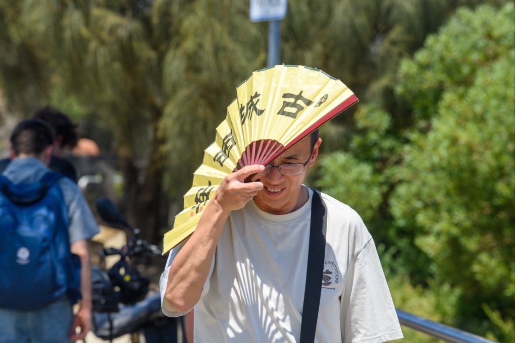 A man shades himself from the heat with a fan in Melbourne, Australia, on Tuesday. Victorians are sweating through what could be the state’s most severe heatwave in nearly two decades. Photo: EPA