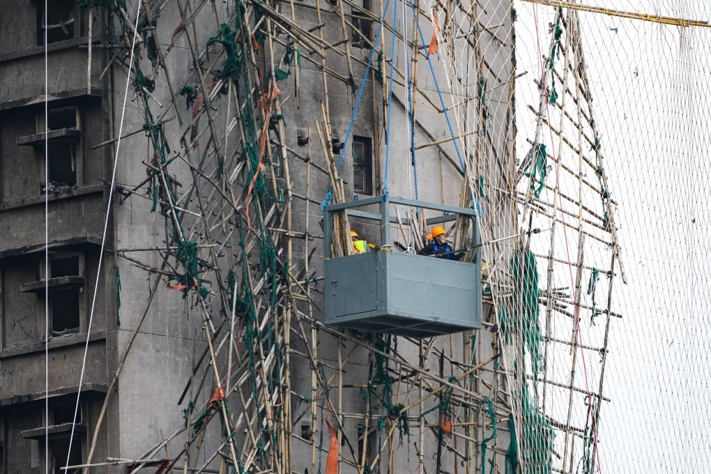 Workers remove damaged bamboo scaffolding at Wang Fuk Court in Tai Po, on January 21. Photo: Sam Tsang