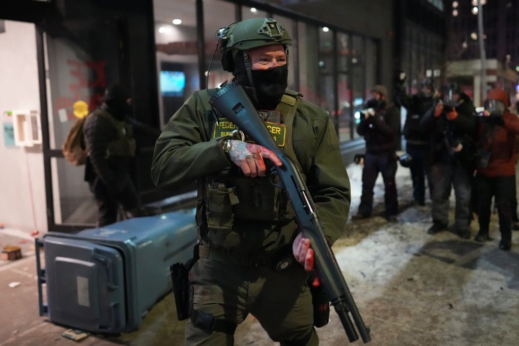 A federal agent stands guard near a hotel during a protest against immigration enforcement operations in Minneapolis. Photo: AP