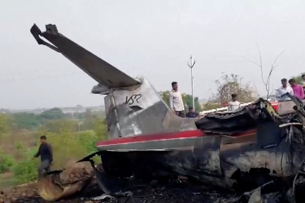 Emergency personnel and bystanders gather at the site of a plane crash in Baramati, Maharashtra, India, on Wednesday. Photo: ANI via Reuters