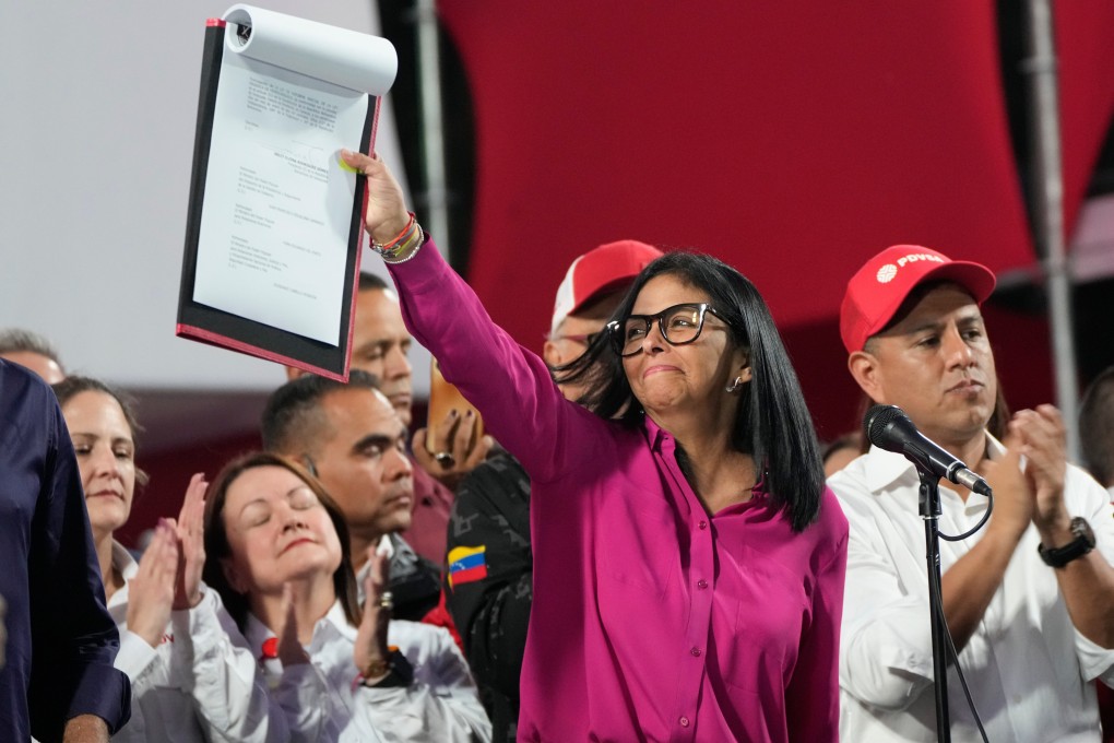 Venezuela’s acting President Delcy Rodriguez holds up a copy of the new law. Photo: AP
