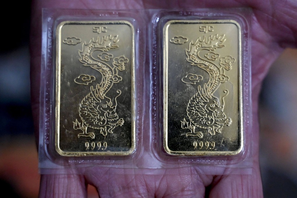 A woman holds gold bars in Hanoi, Vietnam. Photo: AFP