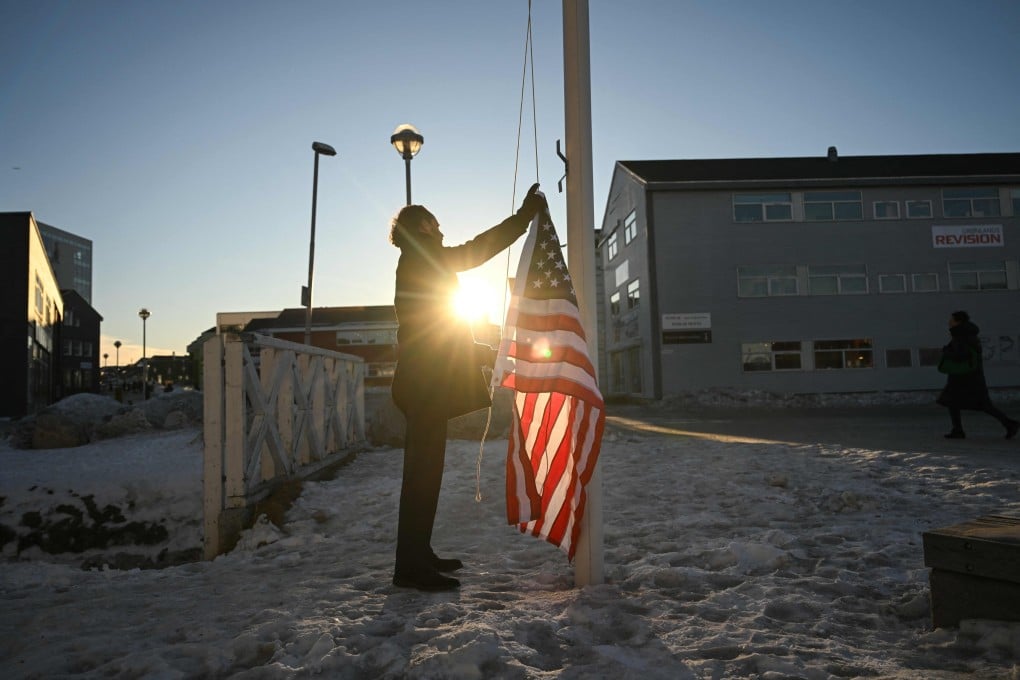 German Comedian Maxi Schafroth tries to raise an American flag in Nuuk, Greenland, on Thursday. Photo: AFP