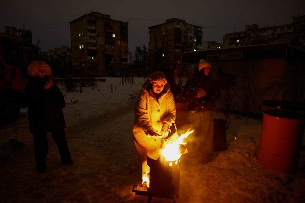 A resident warms up next to fire during a blackout in Kyiv, Ukraine, on Monday. Photo: Reuters
