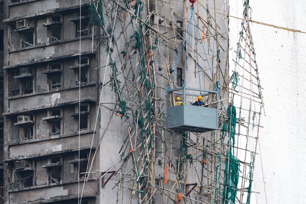 Workers remove the damaged bamboo scaffolding in Wang Fuk Court at Tai Po. Photo: SCMP / Sam Tsang