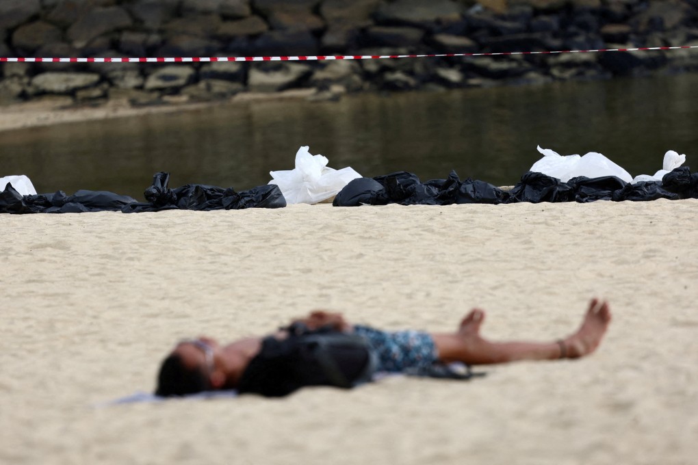 A man sunbathes at Palawan Beach in Singapore’s Sentosa in 2024. The island has suspended all water activities after a crocodile was spotted off Sentosa Cove.