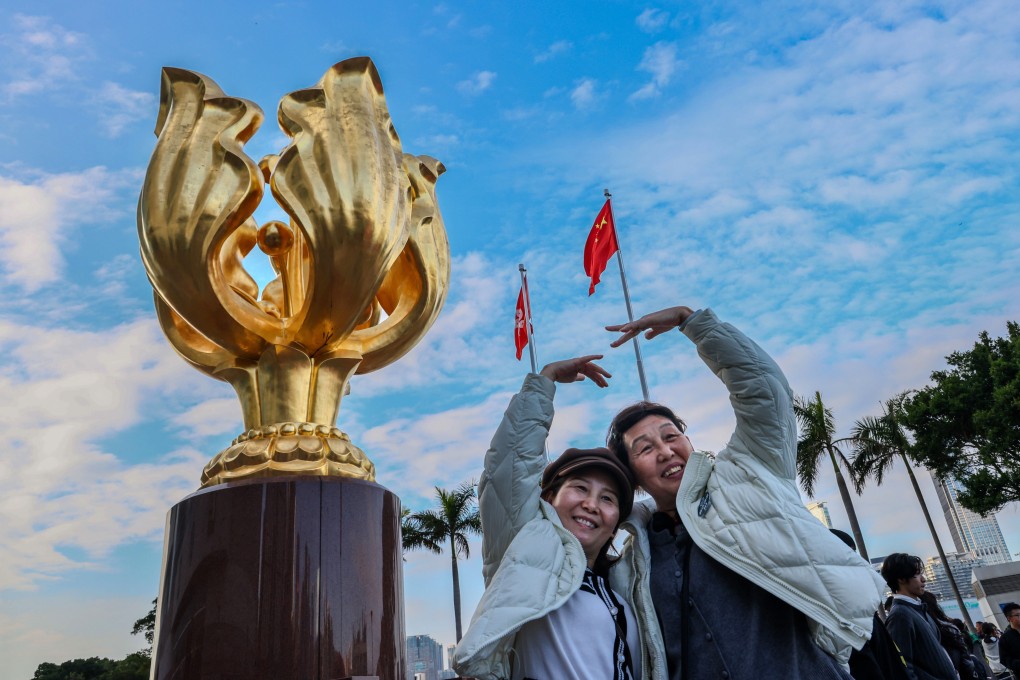 Tourists pose for pictures at Golden Bauhinia Square in Wan Chai. Photo: Dickson Lee