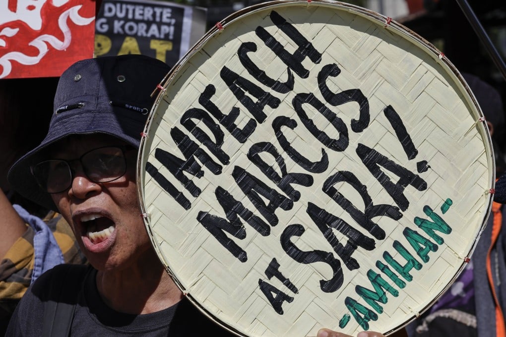A protester holds a sign calling for the impeachment of Philippine President Ferdinand Marcos Jnr and Vice-President Sara Duterte during a rally outside the House of Representatives in Quezon City on Monday. Photo: EPA