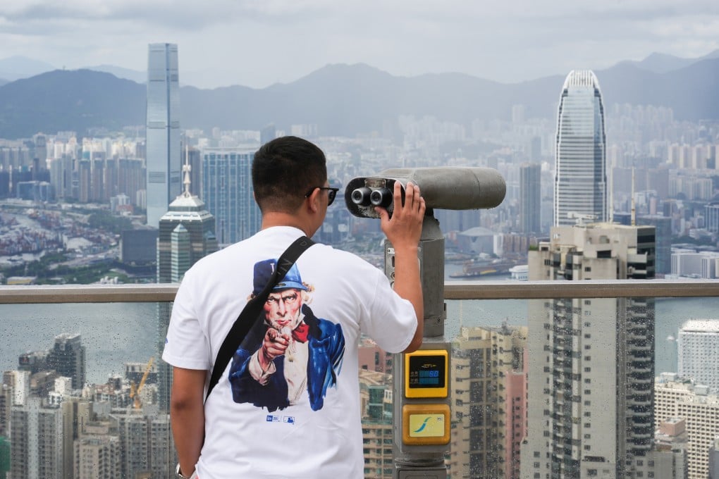A tourist observes Hong Kong’s skyscrapers using binoculars at The Peak Galleria on June 21, 2025. Photo: Eugene Lee