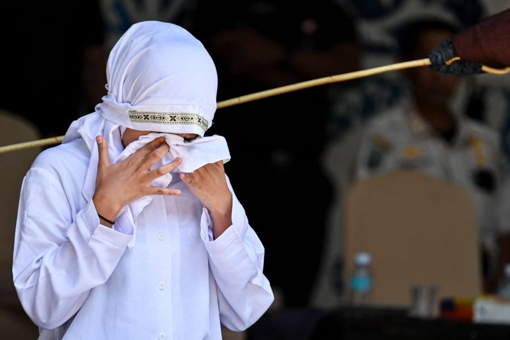 The woman reacts while being publicly caned by a member of the sharia police in Banda Aceh, Indonesia, on Thursday. Photo: AFP
