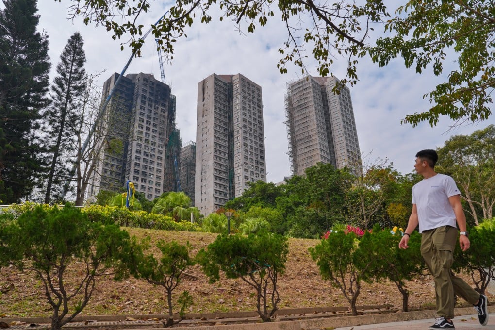 A man in Tai Po’s Yuen Chau Tsai Park, with the charred buildings of Wang Fuk Court in the background. Photo: Elson Li