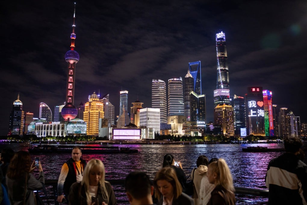 People walk at the Bund by the Huangpu river with skyscrapers of the Lujiazui financial district in the background, in Shanghai. Photo: Reuters