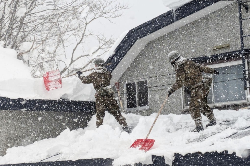 Japanese military personnel remove snow from a rooftop in Aomori, northeastern Japan, on Monday. Photo: Kyodo