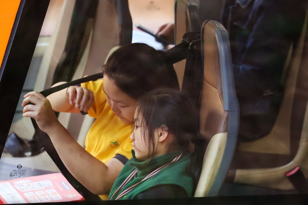 A student tugs at a seat belt on a double-decker bus in Tuen Mun on January 26. Photo: Dickson Lee