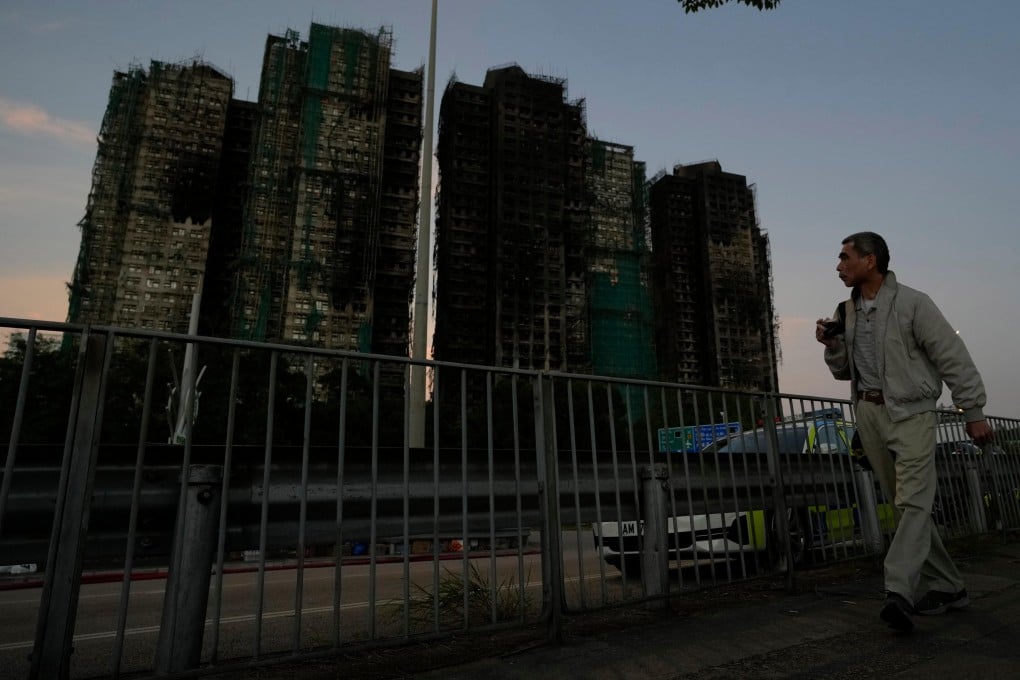A man walks past burnt buildings after the deadly fire at Wang Fuk Court in Tai Po district on November 28 2025. Photo: AP